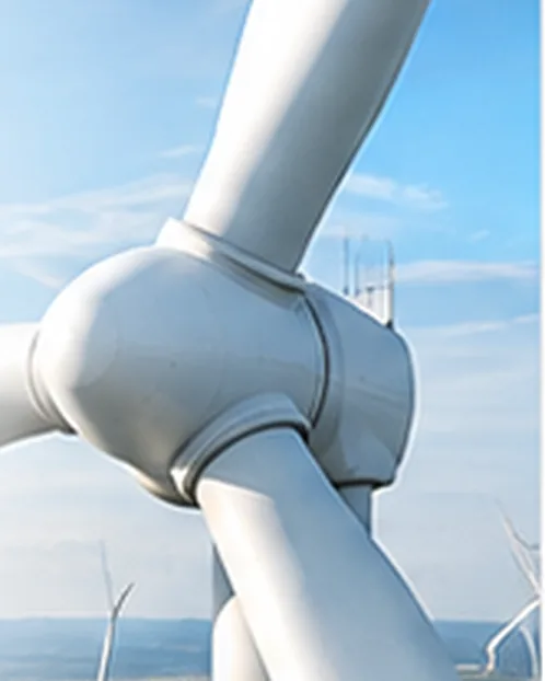 Close-up of a wind turbine hub and blades against a blue sky