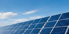 Rows of solar PV panels under a blue sky